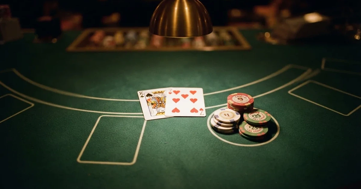 Mesa de jogo iluminada com cartas, vista de cima — blackjack regras para portugueses